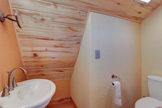 bathroom with lofted ceiling, toilet, wooden ceiling, and sink