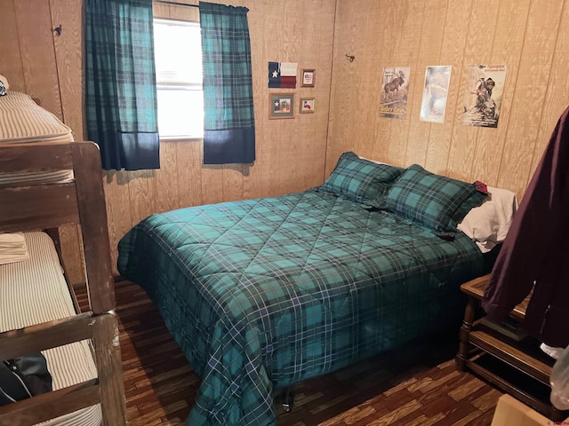 bedroom with wood walls and dark hardwood / wood-style flooring