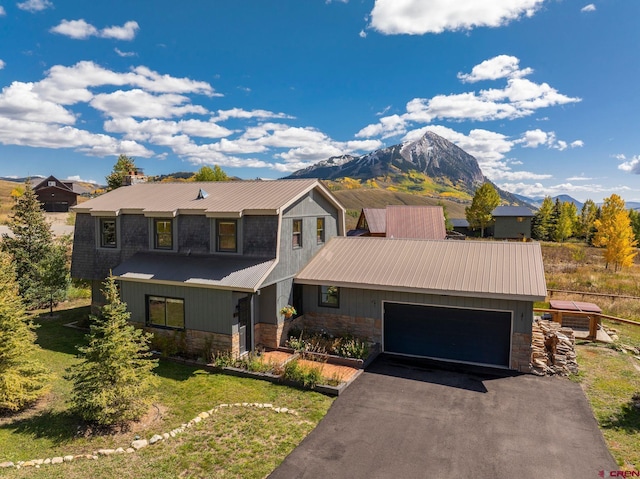 view of front of property with a mountain view, a garage, and a front lawn