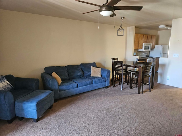 living area featuring light carpet and ceiling fan