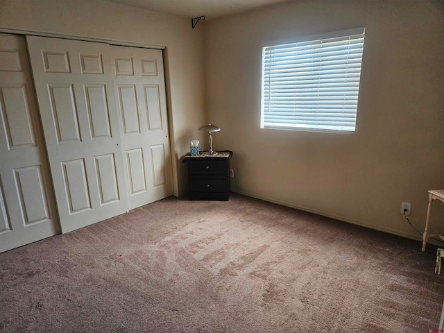 unfurnished bedroom with a closet and carpet flooring