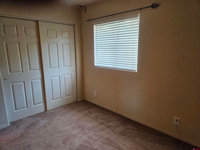 unfurnished bedroom featuring a closet and light colored carpet