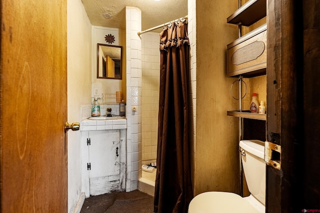 bathroom featuring a textured ceiling, vanity, toilet, and a shower with shower curtain