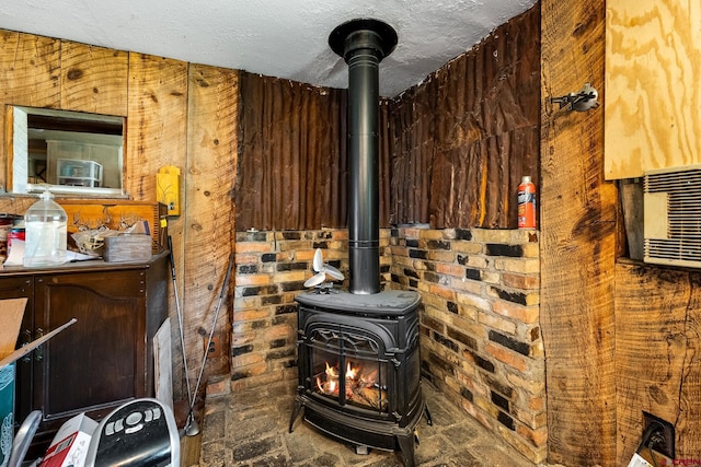 details with a textured ceiling, cooling unit, and a wood stove