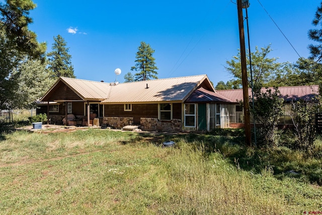 back of property with a lawn and a patio