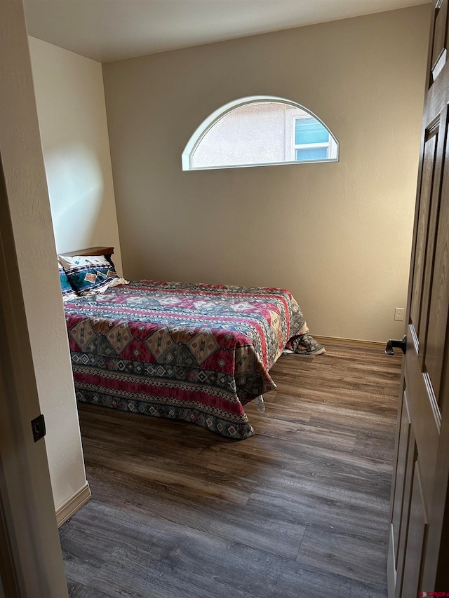 bedroom with dark wood-type flooring