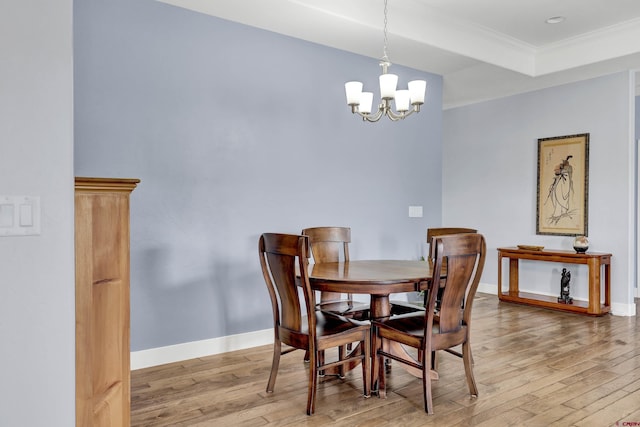 dining area featuring an inviting chandelier, light hardwood / wood-style flooring, and ornamental molding