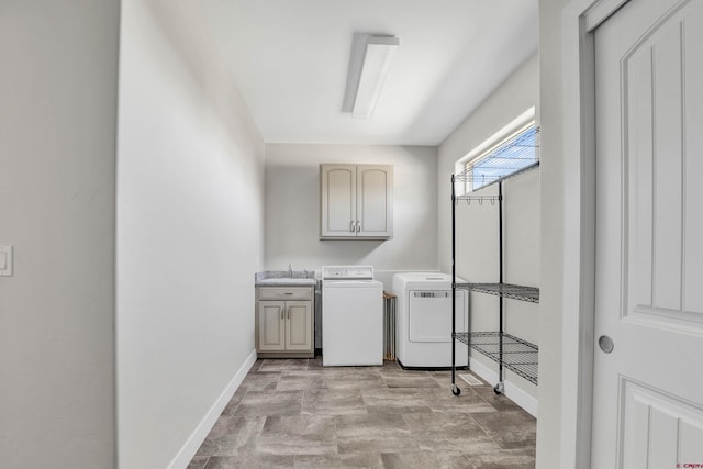 washroom featuring washing machine and clothes dryer, cabinets, and sink