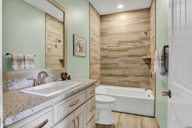 full bathroom featuring wood-type flooring, tiled shower / bath, vanity, and toilet