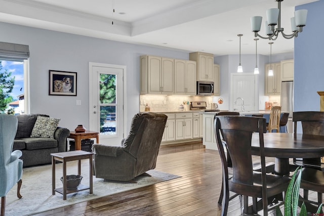 interior space with an inviting chandelier, a wealth of natural light, light wood-type flooring, and sink