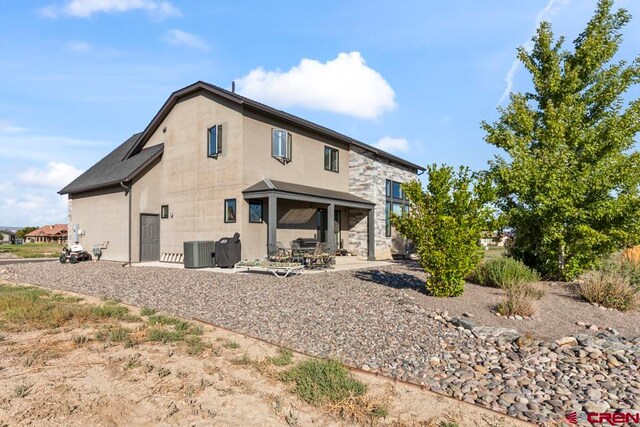 rear view of house with cooling unit and a patio