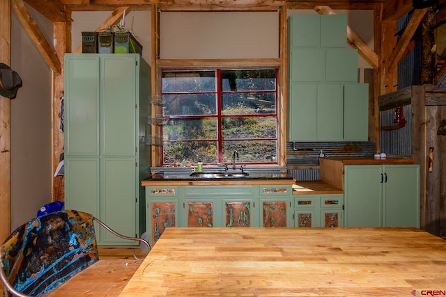 kitchen featuring light hardwood / wood-style flooring, sink, green cabinets, and tasteful backsplash