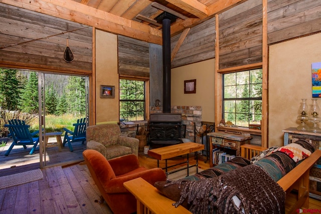 living room with high vaulted ceiling, a wood stove, hardwood / wood-style flooring, and wooden ceiling