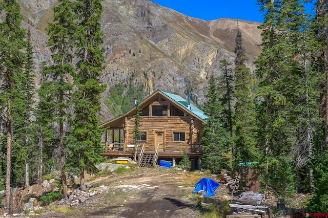 rear view of house with a deck with mountain view