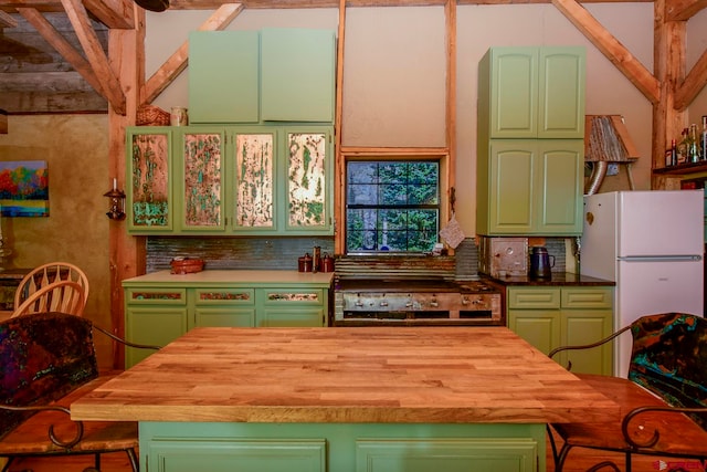 kitchen featuring black range, green cabinets, white refrigerator, and tasteful backsplash