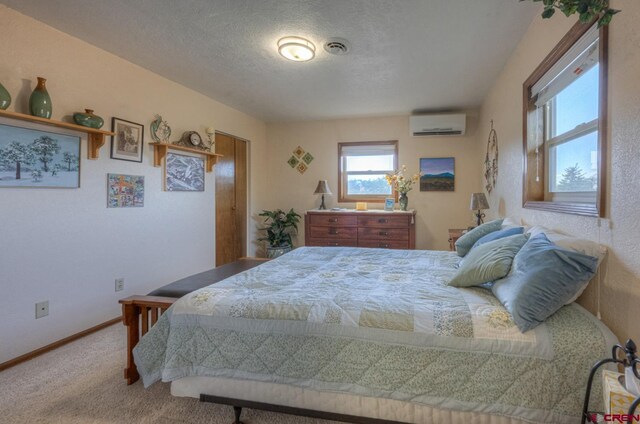 bedroom featuring an AC wall unit, carpet, and a textured ceiling