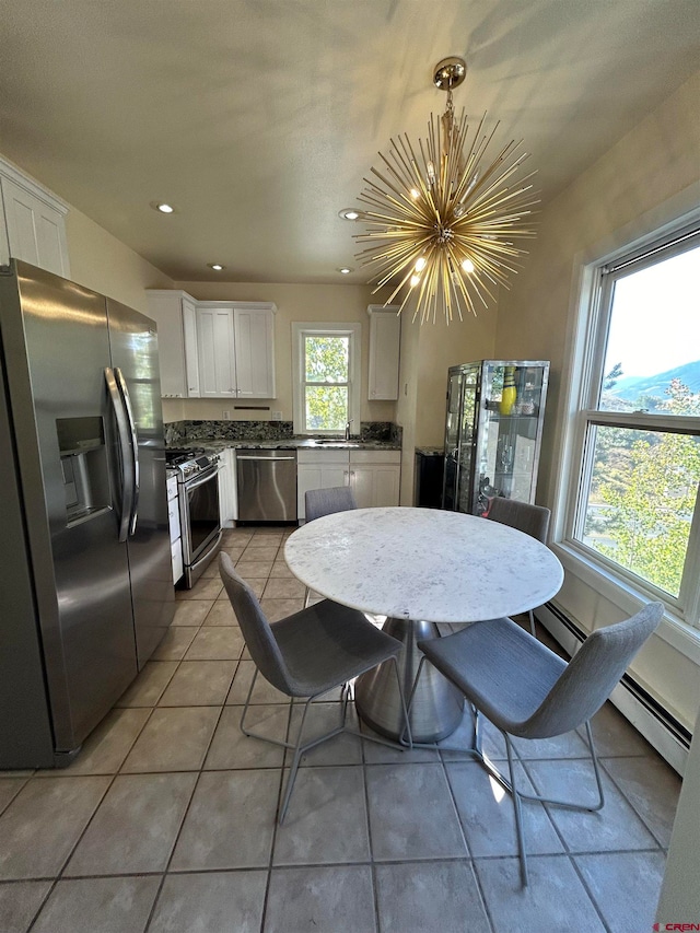 tiled dining room featuring a chandelier, sink, and a baseboard radiator