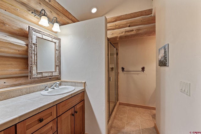 bathroom featuring tile patterned floors, a shower with door, and vanity