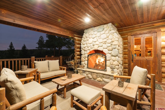 patio terrace at dusk featuring an outdoor stone fireplace