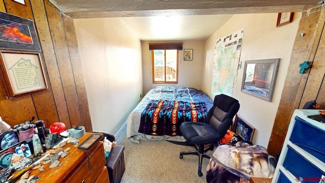 carpeted bedroom with wood walls and vaulted ceiling