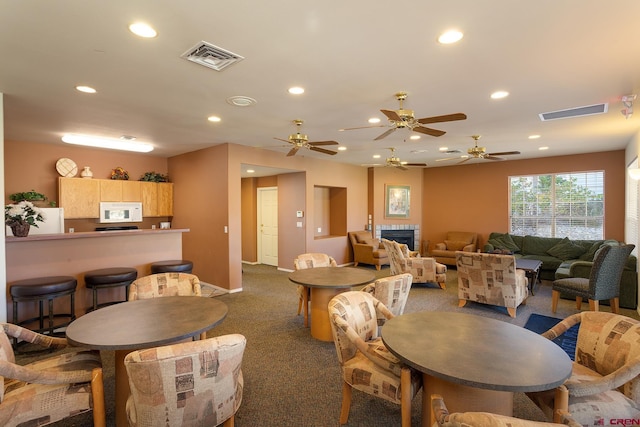 dining area with dark colored carpet and ceiling fan