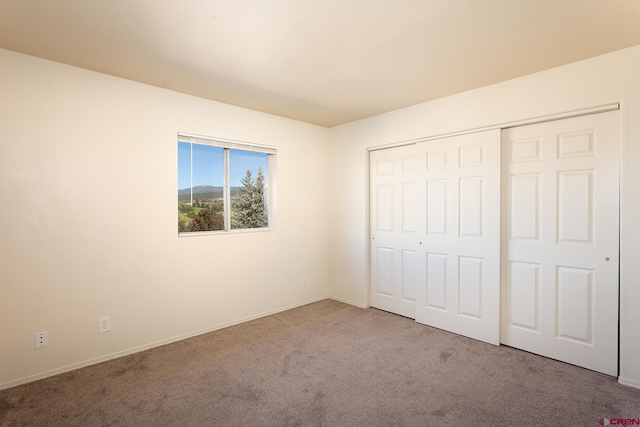 unfurnished bedroom with carpet floors and a closet