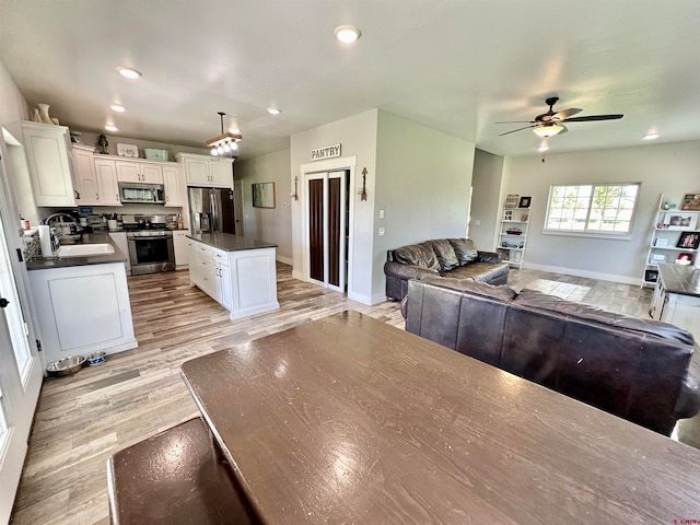 dining area featuring sink, ceiling fan, and light hardwood / wood-style flooring