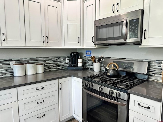 kitchen featuring white cabinetry, dark countertops, and appliances with stainless steel finishes