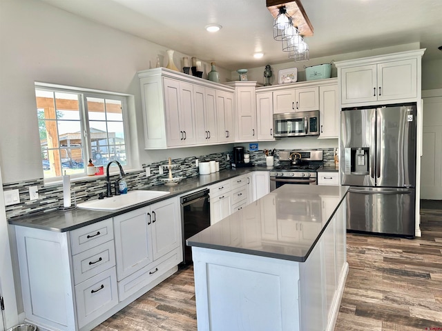 kitchen featuring hardwood / wood-style floors, white cabinetry, sink, and stainless steel appliances