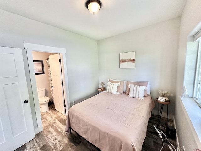 bedroom with ensuite bath and wood finished floors