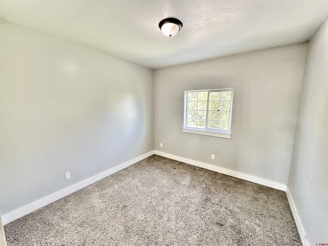 unfurnished room featuring carpet floors and baseboards
