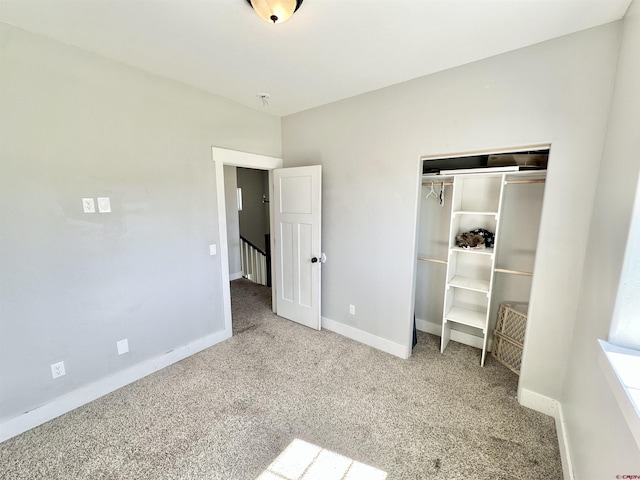 unfurnished bedroom with a closet, carpet floors, and baseboards