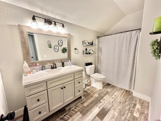 bathroom with vanity, toilet, curtained shower, wood-type flooring, and vaulted ceiling