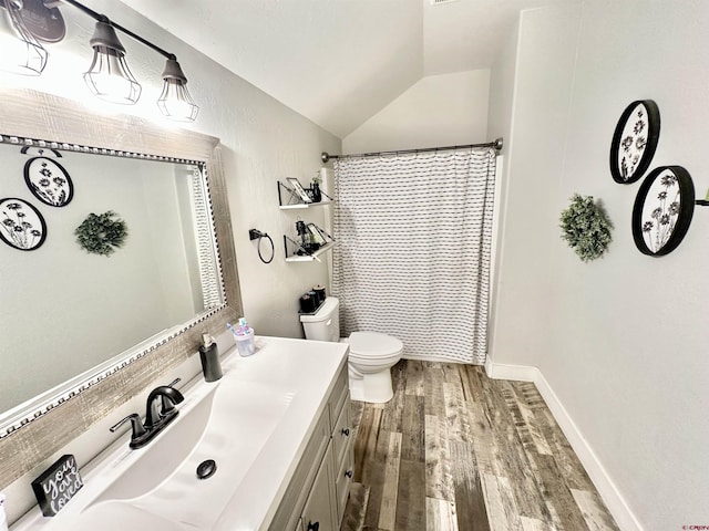 full bathroom featuring baseboards, toilet, wood finished floors, vanity, and lofted ceiling