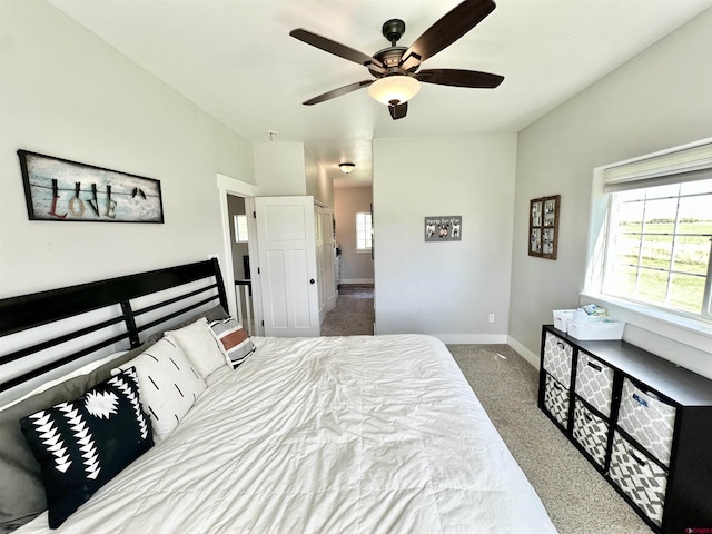 bedroom with a ceiling fan, carpet floors, baseboards, and multiple windows