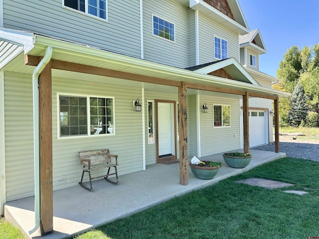 doorway to property with a lawn, a porch, and a garage