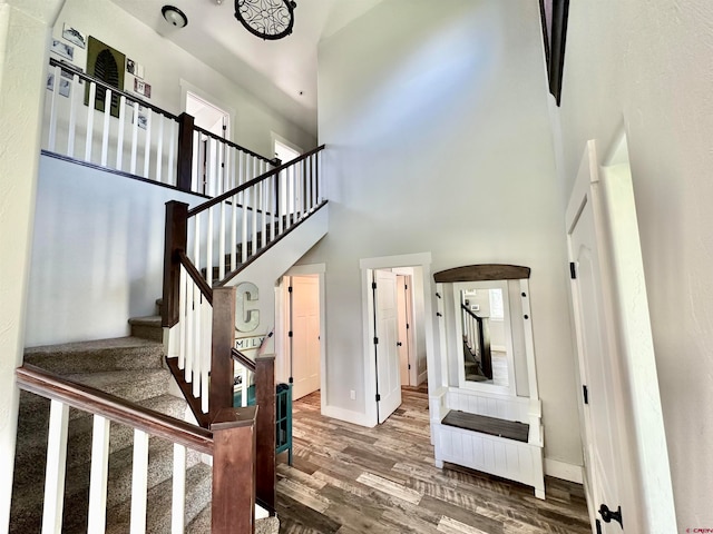 stairway with a high ceiling and hardwood / wood-style floors