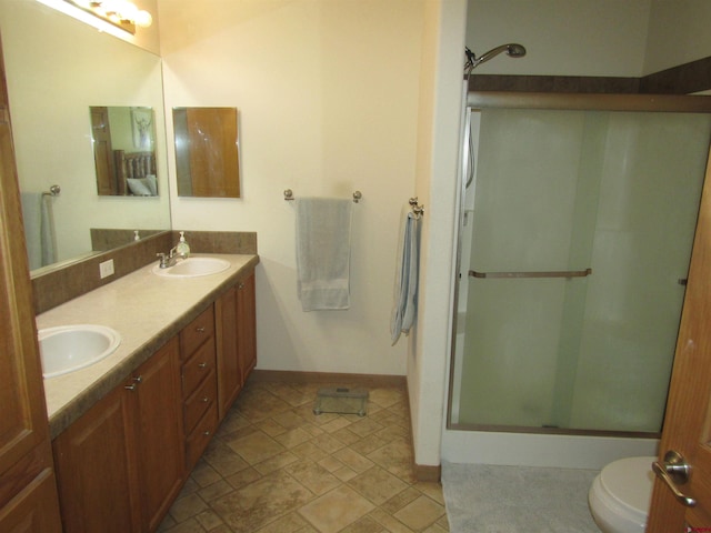 bathroom featuring vanity, toilet, and a shower with door