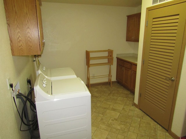 washroom with separate washer and dryer and cabinets