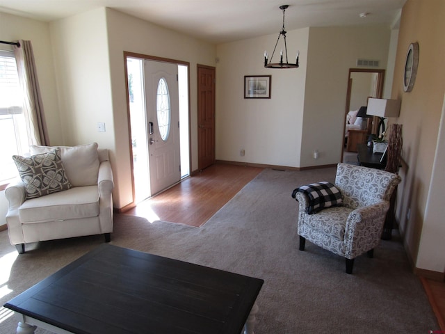 living room with an inviting chandelier and hardwood / wood-style flooring