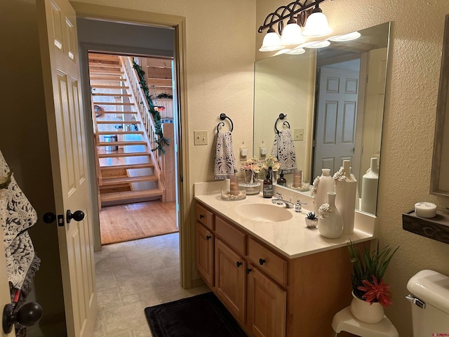 bathroom with wood-type flooring, vanity, and toilet
