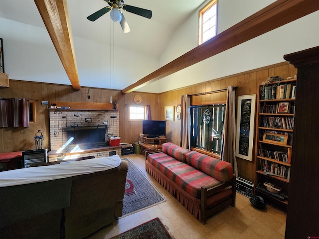 living room with ceiling fan, wood walls, beam ceiling, a brick fireplace, and high vaulted ceiling