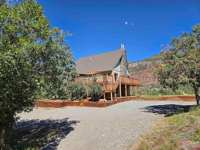 back of house with a deck with mountain view