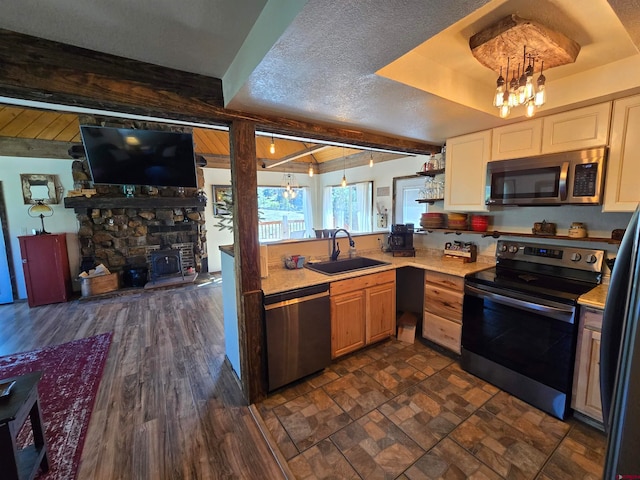 kitchen featuring beam ceiling, an inviting chandelier, sink, and stainless steel appliances