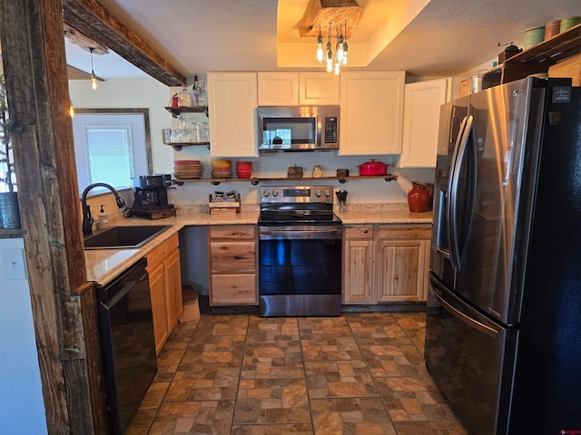 kitchen featuring appliances with stainless steel finishes, beam ceiling, sink, and white cabinets