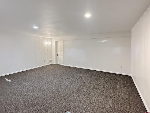 unfurnished room with dark colored carpet