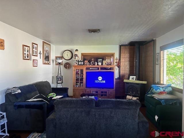 living room with a textured ceiling and a wood stove