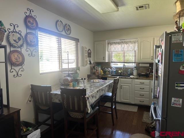 kitchen featuring stainless steel fridge, dark hardwood / wood-style flooring, sink, and white cabinets