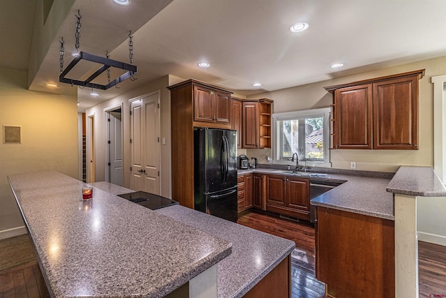 kitchen featuring black appliances, a kitchen island, and dark hardwood / wood-style flooring