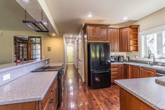 kitchen with black appliances, dark hardwood / wood-style floors, and sink